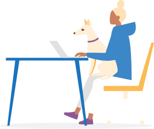 Person sitting at a desk typing at a laptop with a dog on their lap