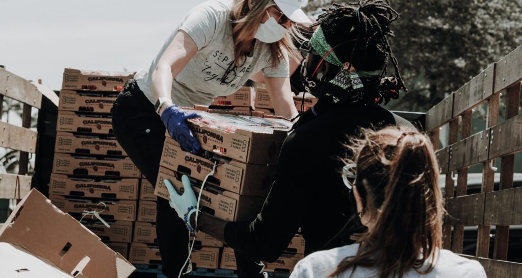 Group of people helping to move crates of strawberries